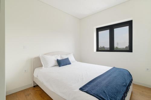 a white bed in a white room with a window at Casa Pitoresca - Refugio Esposende in Braga