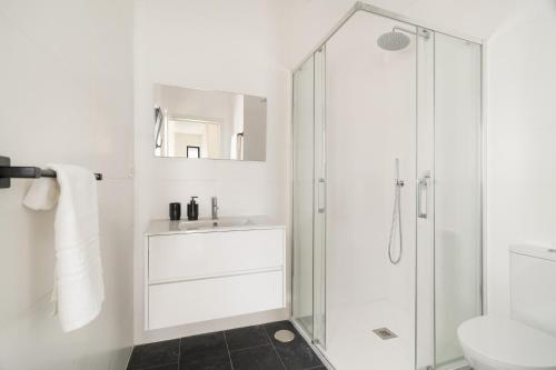 a white bathroom with a shower and a sink at Casa Pitoresca - Refugio Esposende in Braga