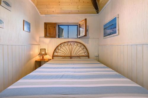 a bedroom with a large bed with a wooden headboard at Villa Ondina 1 Carloforte in Carloforte