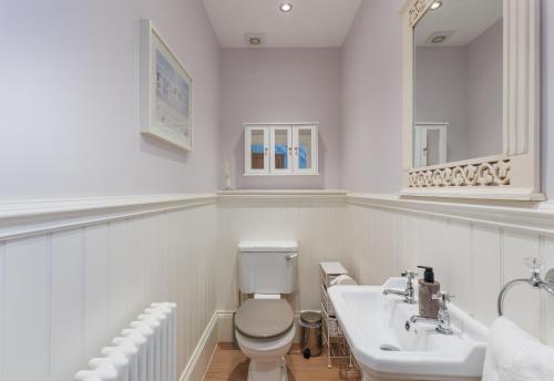 a white bathroom with a toilet and a sink at 5 Old School Mews Shanklin in Shanklin