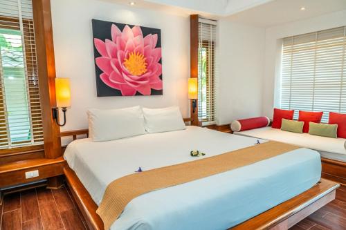 a bedroom with two beds and a flower painting on the wall at Centara Villas Samui in Lamai