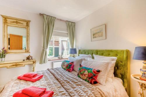 a bedroom with a bed with pillows and a mirror at 2 Bed in Great Witchingham oc-p45227 in Reepham