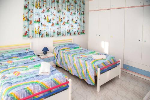 a bedroom with two beds and a curtain at VILLA LAGEM, Casa con piscina, barbacoa, jardín in Cubelles