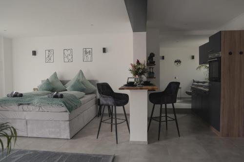 a living room with a couch and a table and stools at Ferienwohnung Eifelmomente in Rittersdorf