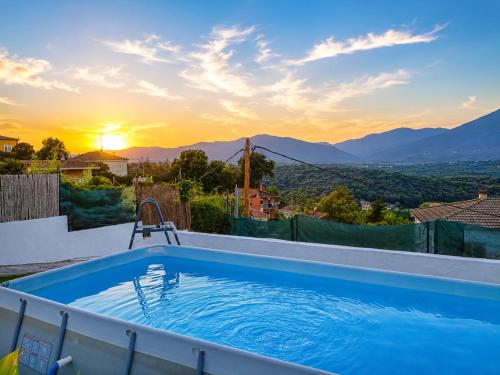 a swimming pool on the roof of a house with the sunset at Ca la Nena Morena - Casa con piscina privada, jardín y vistas al Montseny in Vallgorguina
