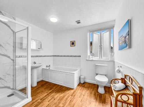 a bathroom with a tub sink and a toilet at Keld Apartment Porlock in Porlock