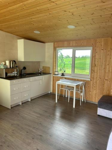 a kitchen with a table and a window at Atostogų namelis Stebuliuose in Stebuliai