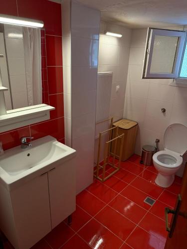 a bathroom with a white sink and a toilet at Το Σπίτι στον Πεζόδρομο in Grevena