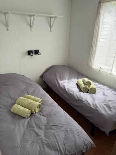 two beds in a room with towels on them at Chez Axel in Pradons