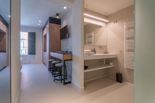 a kitchen with a bar and a sink in a room at Edificio Ferrari 4, by Plaza Mayor Apartamentos in Valladolid