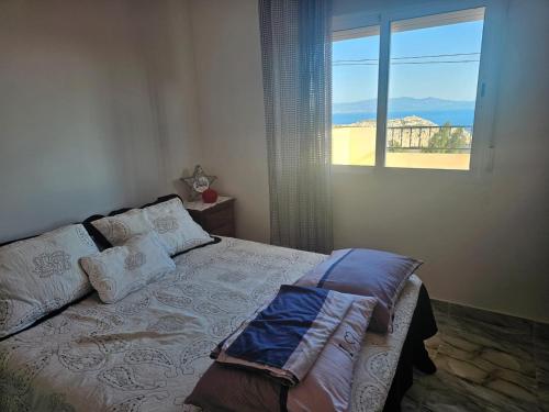 a bedroom with a bed with a large window at Belyounech in Belyounech 