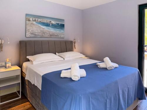 a bedroom with a blue bed with towels on it at Beachfront Villa San't Antonio Podaca in Podaca