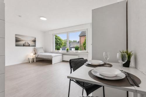 a white living room with a table and chairs at NM living Lünen VII in Lünen