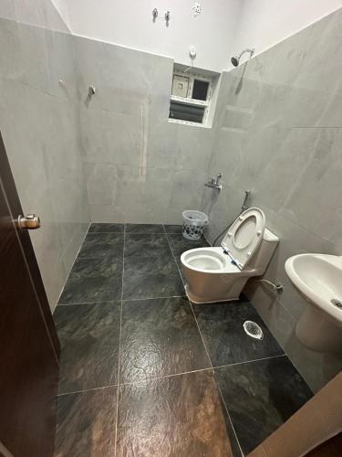 a bathroom with a toilet and a sink at Hotel Siri Inn Hitech City in Hyderabad