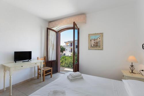 ein Schlafzimmer mit Bett, Schreibtisch und Fenster in der Unterkunft Nurache in Orosei