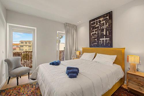 a bedroom with a bed and a chair and a window at Trafaria Bliss in Trafaria