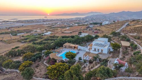 an aerial view of a house on a hill with the sunset at Primadonna Luxury Villas in Mikonos