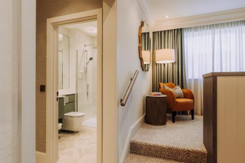 a bathroom with a toilet and a chair in a room at Skiddaw Hotel in Keswick