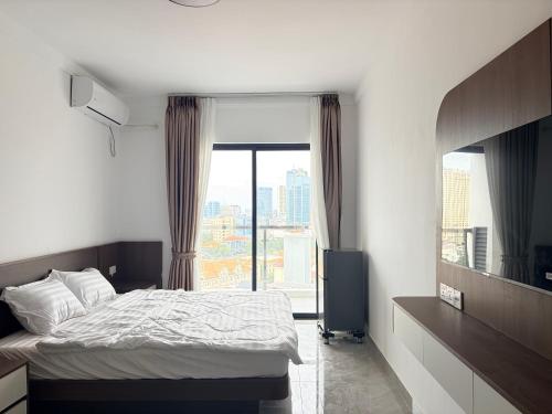 a bedroom with a bed and a large window at FryB in Phnom Penh