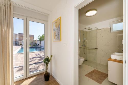 a bathroom with a shower and a toilet and a window at Kuća za odmor Leona in Dušić