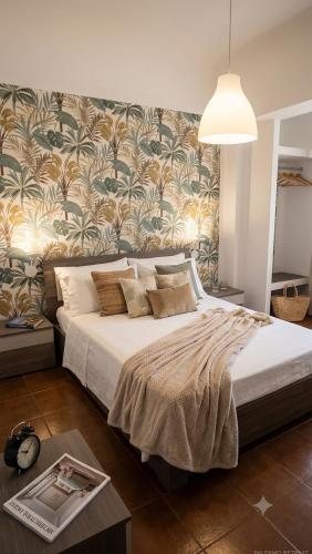 a bedroom with a large bed with a floral wall at Dimora Filangeri in Santa Flavia