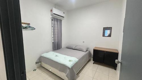 a small bedroom with a bed and a window at Homestay Atok Mus'lim Only in Jenjarum