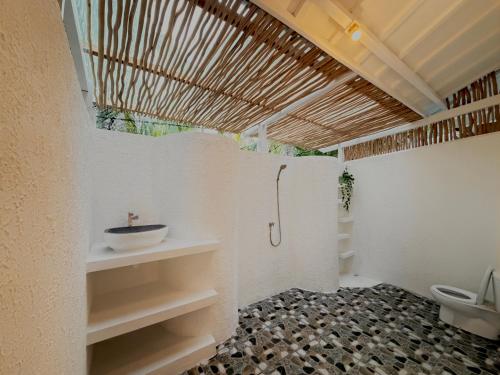 a bathroom with a sink and a toilet in it at Bronze Bungalows in Gili Meno