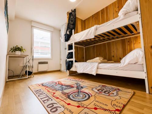 a room with two bunk beds and a rug on the floor at La Beaujoire in Nantes