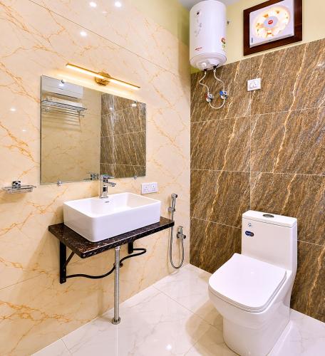 a bathroom with a sink and a toilet and a mirror at Wildline Gold Resort in Dhikuli