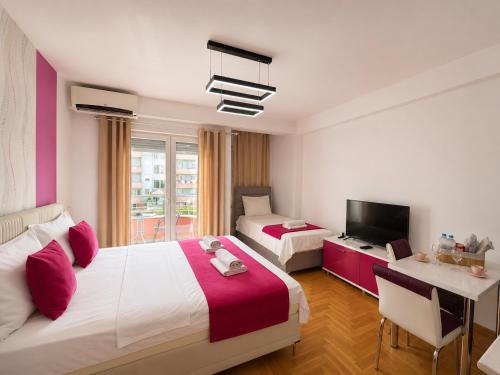 a hotel room with two beds and a television at Front Beach Exclusive Apartments in Struga