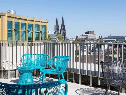 a group of blue tables and chairs on a balcony at 25hours Hotel The Circle in Cologne