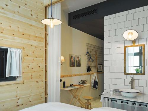 a bathroom with wooden walls and a sink and a mirror at 25hours Hotel The Royal Bavarian in Munich