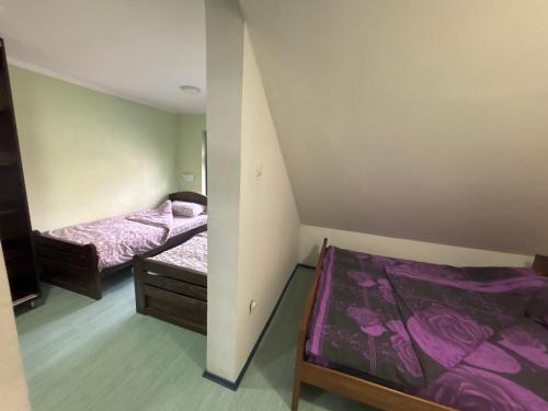 two beds in a small room with purple sheets at Staro Lane in Sjenica