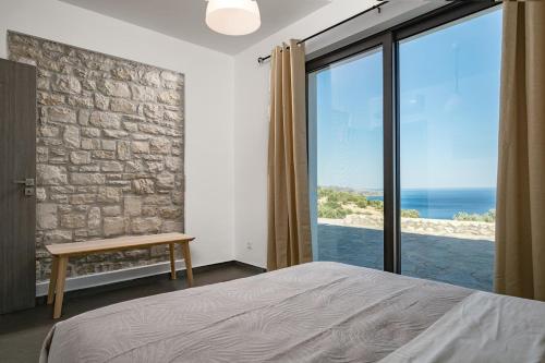 a bedroom with a bed and a view of the ocean at Villa Belo in Kastrí