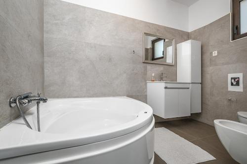 a bathroom with a white tub and a sink at Villa Belo in Kastrí