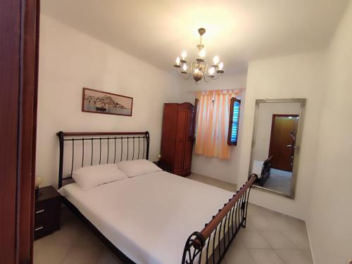 a bedroom with a large bed and a mirror at Apartment Skroza in Žirje