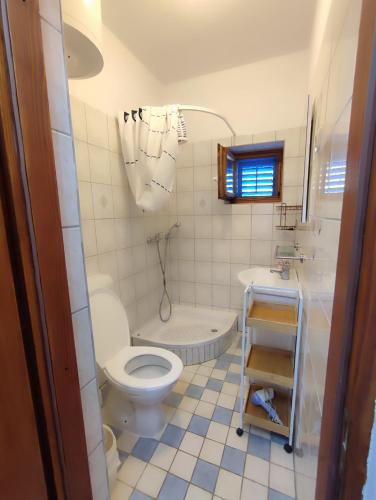 a bathroom with a toilet and a sink and a tub at Apartment Skroza in Žirje