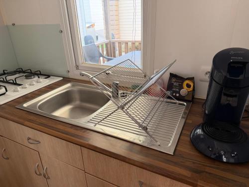 a dish rack sitting on top of a kitchen sink at Chez Axel in Pradons