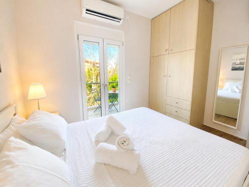 a bedroom with a white bed with towels on it at Elli's House - Apartment in Lixouri