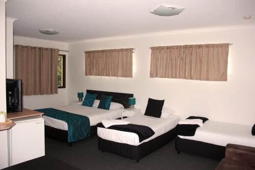 a hotel room with two beds and a television at Motel in Nambour in Nambour
