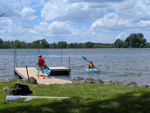 two people on kayaks on a dock on a lake at River & Nature - Nook Richelieu in Henryville