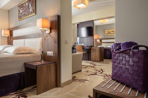 a hotel room with a bed and a living room at New Belvedere in Mangalia