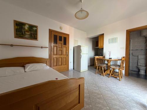 a bedroom with a bed and a kitchen with a table at Apartmani Kovačić in Kraj