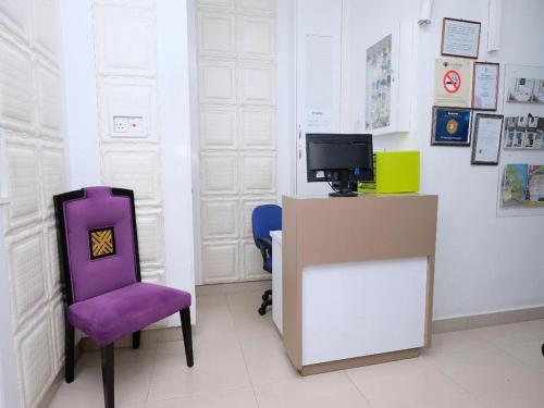 a room with a purple chair and a tv at TY Hotel in Kuala Terengganu
