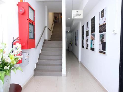 a hallway with a red door and stairs in a building at TY Hotel in Kuala Terengganu