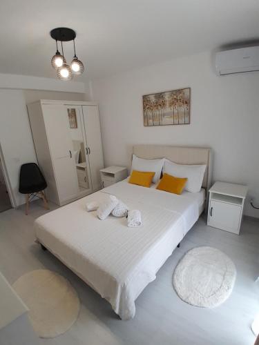 a bedroom with a large white bed with towels on it at Garsoniera Serena in Saturn