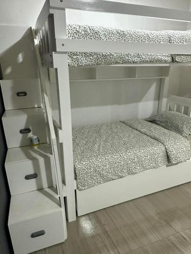 a bedroom with a bunk bed with a white bunk bed frame at A.C. Asistin Transient House in Baguio