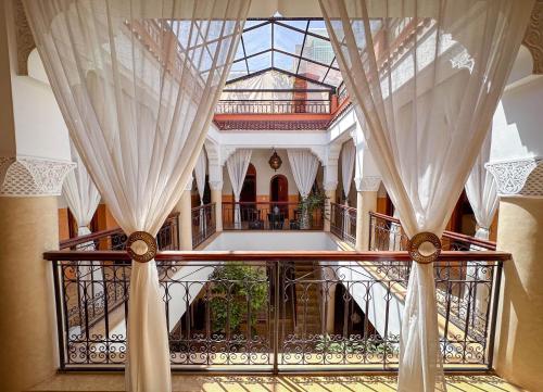 a hallway with a glass ceiling and a balcony with curtains at Riad Nirvana in Marrakesh