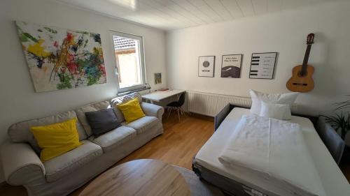 a living room with a couch and a guitar at Ferienhaus am Main in Veitshöchheim