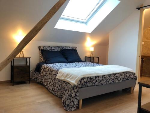 a bedroom with a bed and a skylight at Gîte 4 personnes in Brantôme